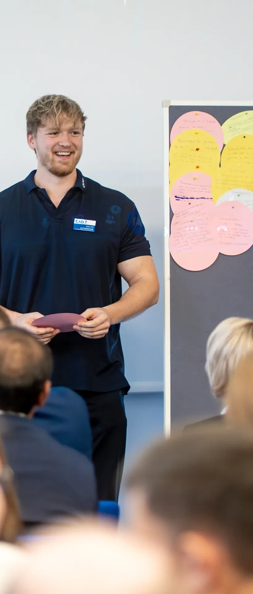 Mitarbeiter moderiert einen Workshop vor einem Flipchart mit Moderationskarten